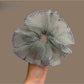 Purple scrunchie with white polka dots and purple trim on a white background