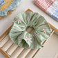 Gifty scrunchie placed next to matching hair accessories