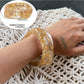 Lovra vintage wide irregular shaped bangle bracelet resting on textured surface