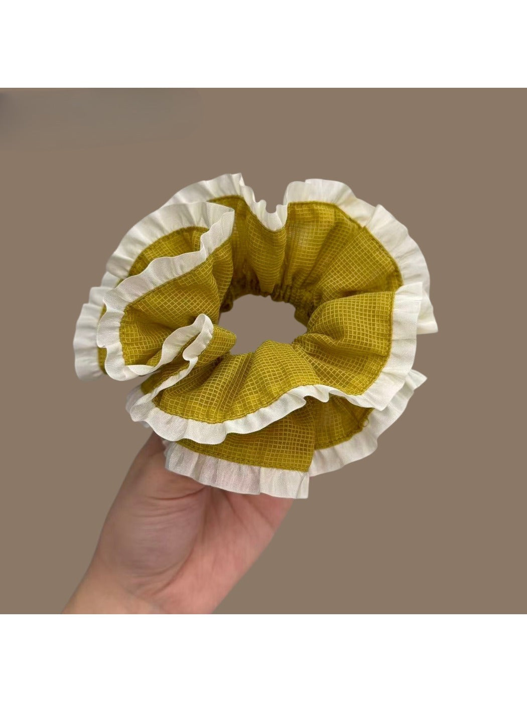 Close-up of green plaid fabric and white trim on scrunchie
