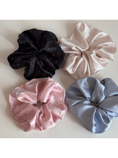 Side view of pink satin scrunchie adorned with clear rhinestones