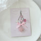 Pink star keychain displayed on a wooden surface with soft lighting