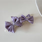 Beau satin bow banana clip styled in loose waves on model's hair
