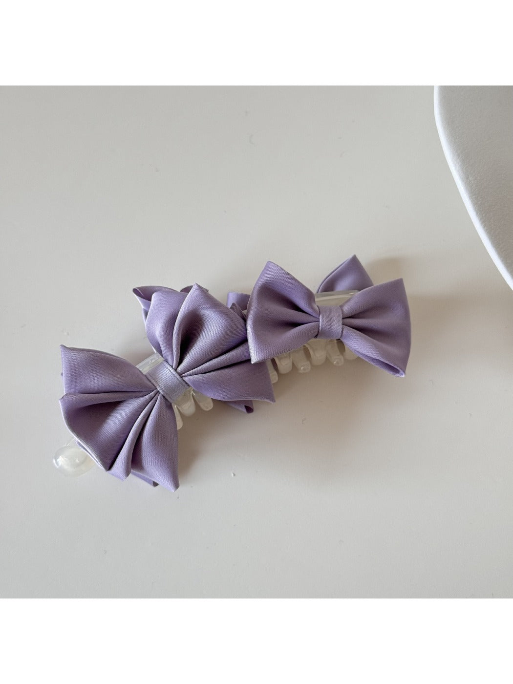 Beau satin bow banana clip styled in loose waves on model's hair