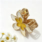 Beau hair clip attached to brown hair, highlighting its rustic floral design