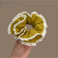 Green plaid scrunchie with white trim on a white background