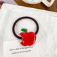Multiple fruit-themed hair ties displayed on a white surface