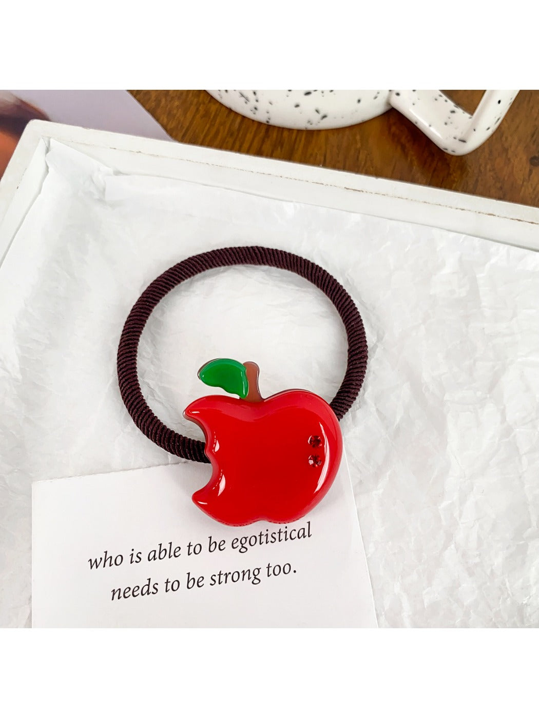 Multiple fruit-themed hair ties displayed on a white surface