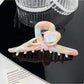 Beau hair claw clip placed on wooden surface with natural lighting