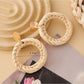 Earedge rattan woven round hollow earrings styled with casual outfit