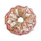 Red floral scrunchie worn on wrist as a hair accessory