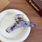 Beau acetate curved claw clip resting on white surface, angled view