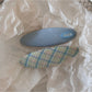 Beau colorful oval hair clip displayed with packaging on a neutral background