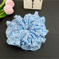 Scrunchie stretched to show elastic band inside black polka dot fabric