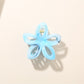 Beau flower hair clip held in hand showing size and intricate openwork details