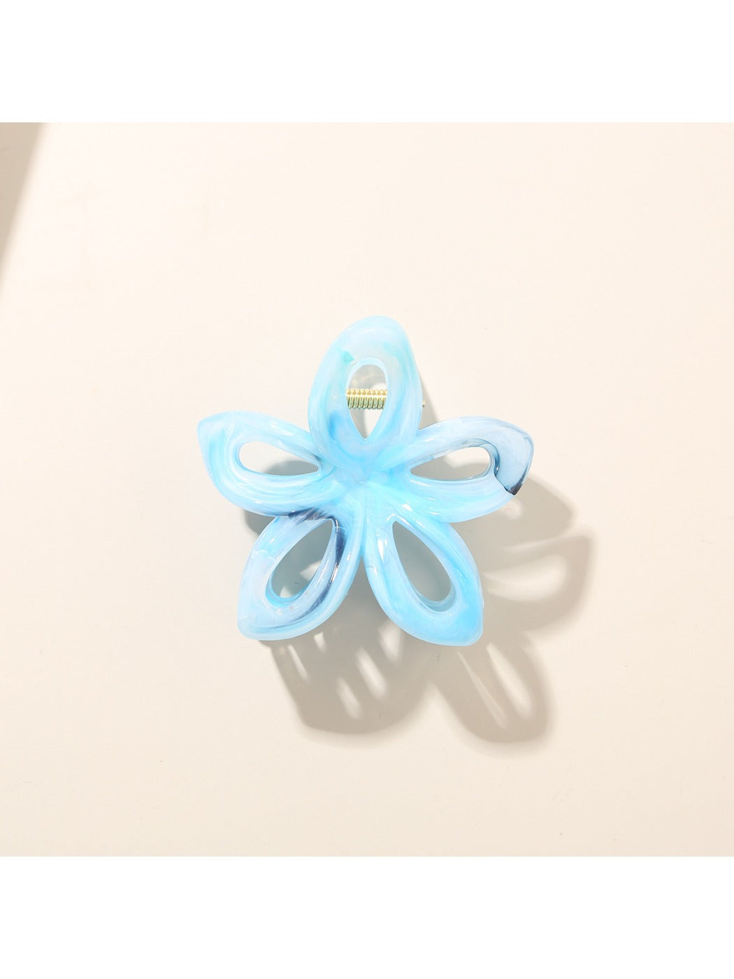 Beau flower hair clip held in hand showing size and intricate openwork details