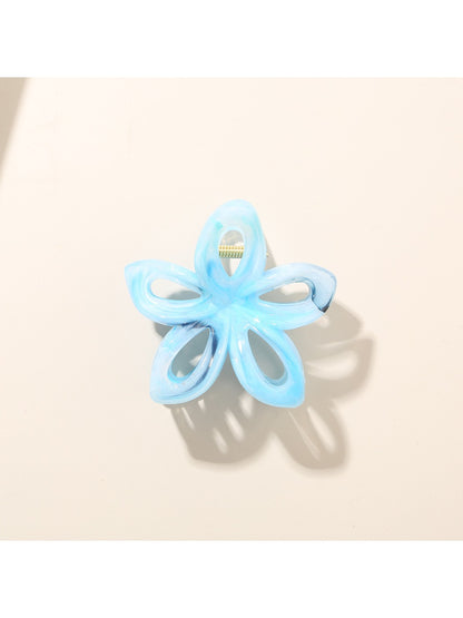 Beau flower hair clip held in hand showing size and intricate openwork details