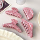 Side view of Beau pink plaid crescent shaped claw clip showing clasp mechanism