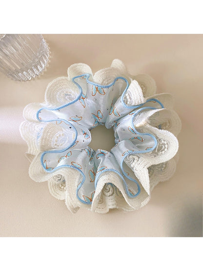 Blue lace trim scrunchie styled on a wooden surface