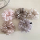 Flat lay of multiple solid color scrunchies arranged on a white background