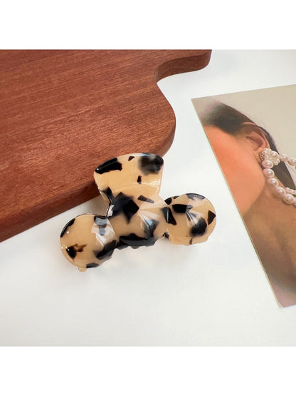 Beau hair claw clip on a fabric surface highlighting texture and color