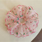 Close-up of pink double layered ruffled scrunchie on white background