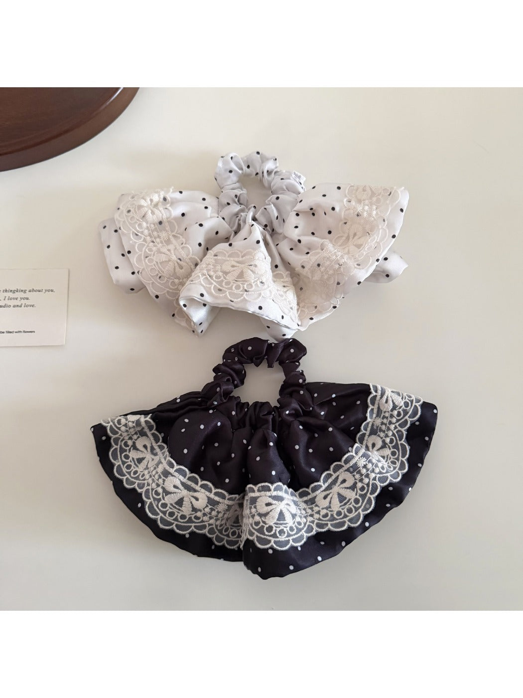 Close-up of Gifty vintage polka dot hair tie in black with white dots