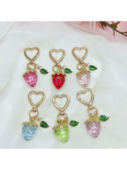 Hand holding Keypus strawberry charm keychain showing detailed texture