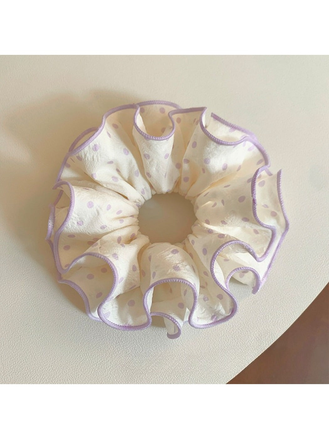 Purple polka dot scrunchie styled with casual outfit on a model