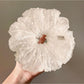 White tulle scrunchie with polka dots styled in a woman's hair