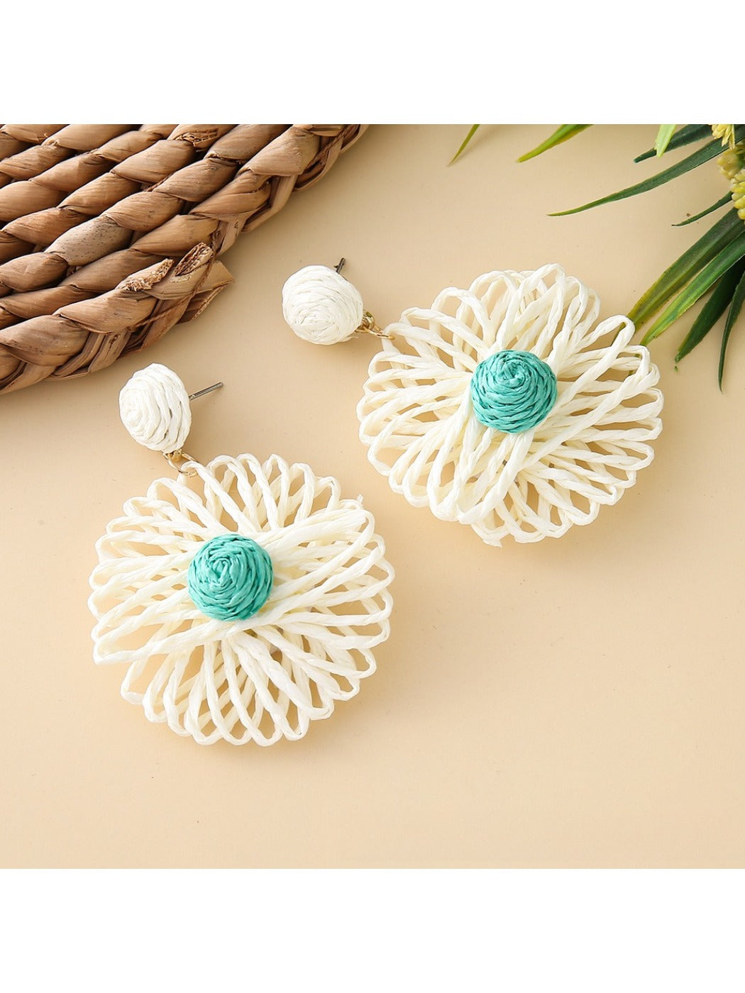 Model wearing raffia sunflower shaped earrings with short hair and white top