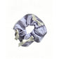Gifty scrunchie with red ribbon bow displayed on a wooden surface