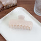 Beau square hair claw clip displayed on a wooden surface