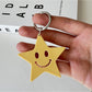 Silver star pendant keychain displayed on a reflective black surface