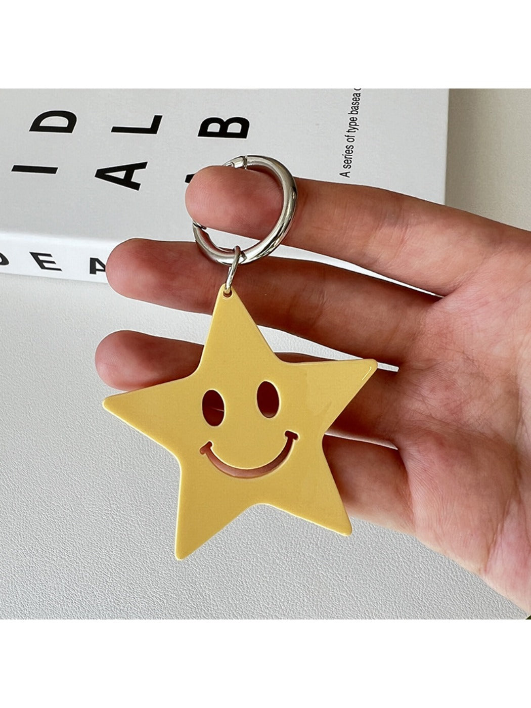 Silver star pendant keychain displayed on a reflective black surface
