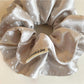 Gifty satin scrunchie styled on a wrist with visible polka dot pattern