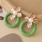 Model wearing Earedge round floral pendant earrings with floral pattern