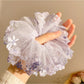 Gifty scrunchie displayed on a white background highlighting ruched floral design