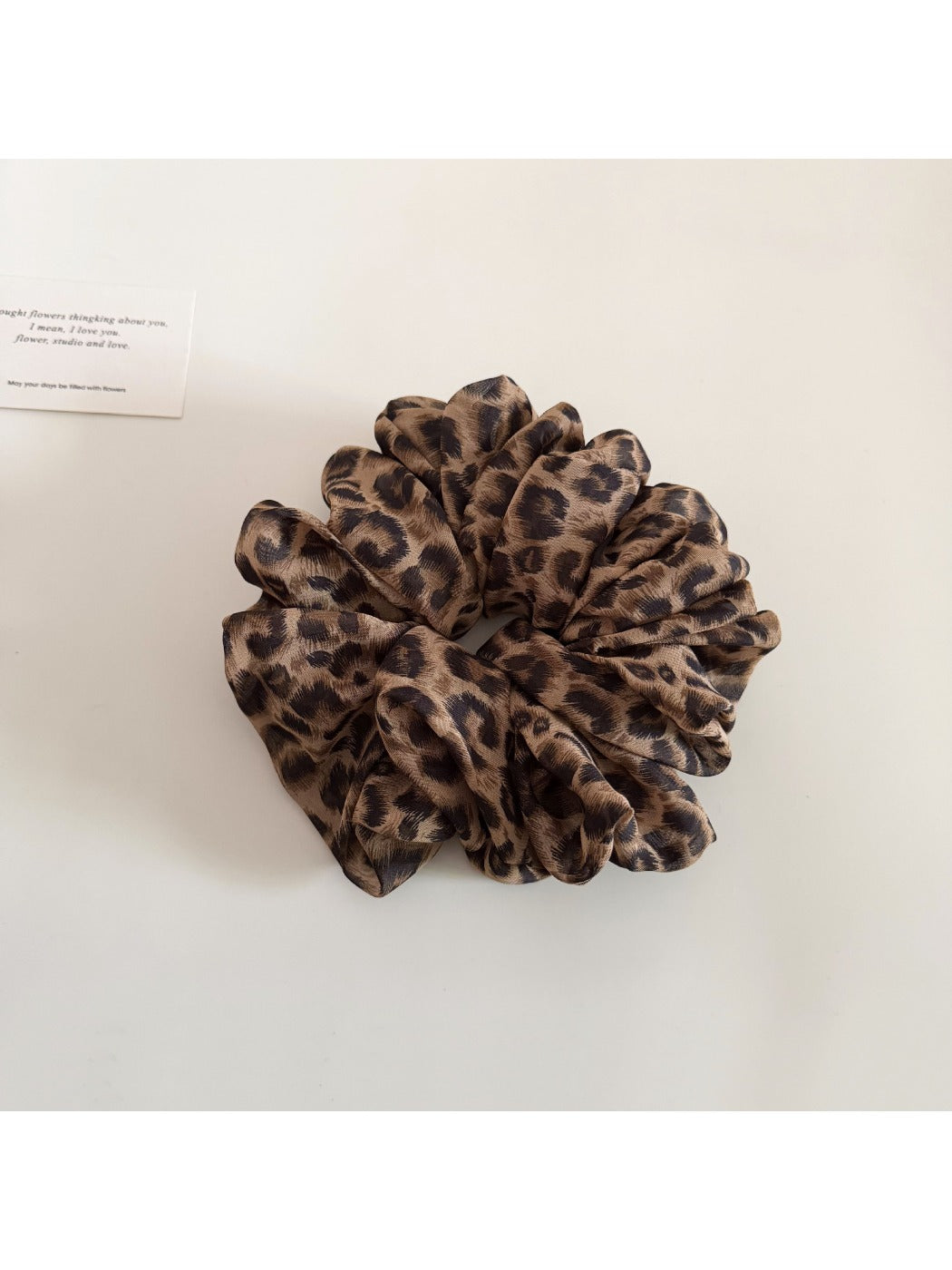 Vintage style leopard print scrunchie placed next to matching hair accessories