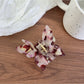 Top view of pastel pink butterfly claw clip showing symmetrical wings