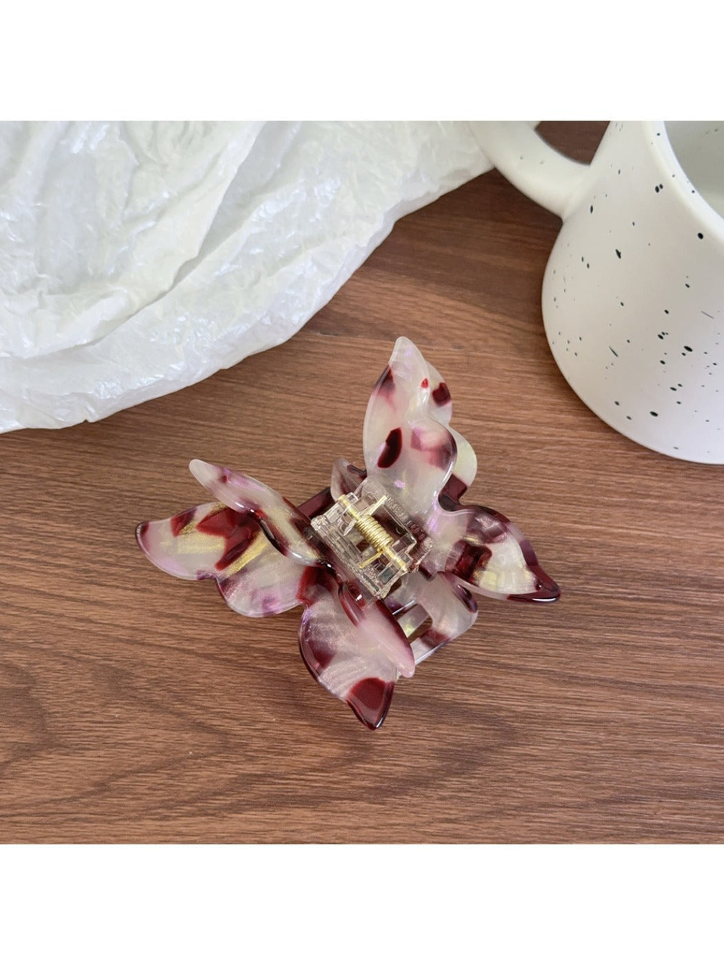 Top view of pastel pink butterfly claw clip showing symmetrical wings