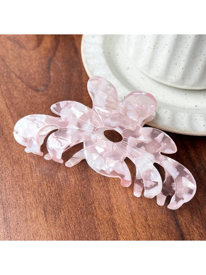 Beau flower shaped claw clip displayed on a flat surface with petals spread