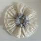 Beige lace scrunchie placed next to matching hair accessories on table