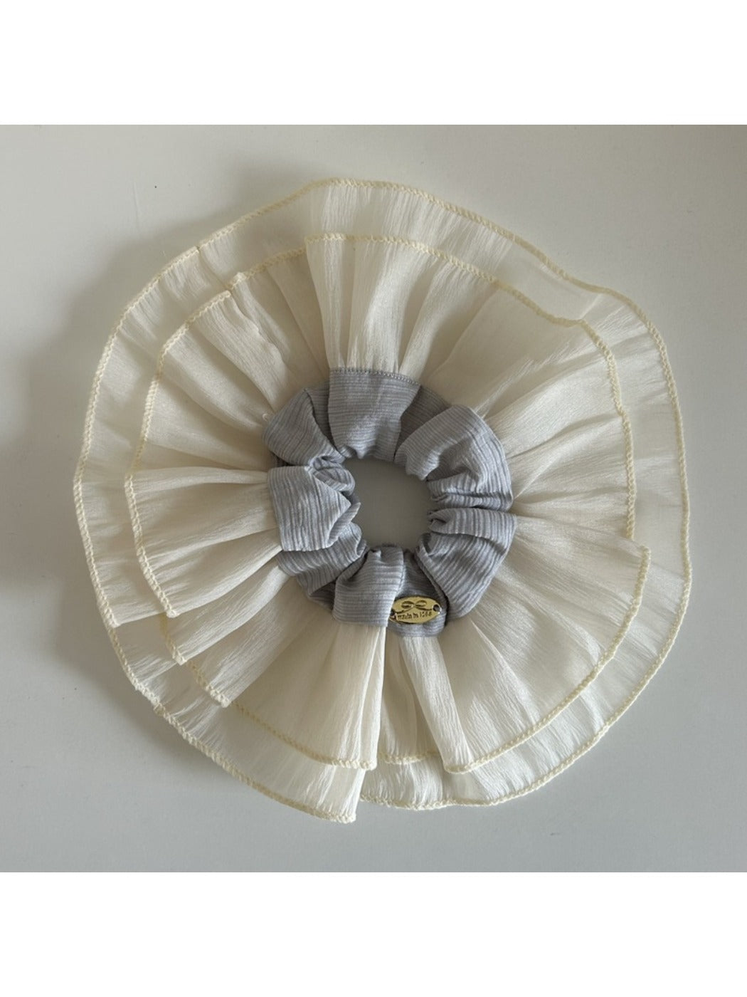 Beige lace scrunchie placed next to matching hair accessories on table