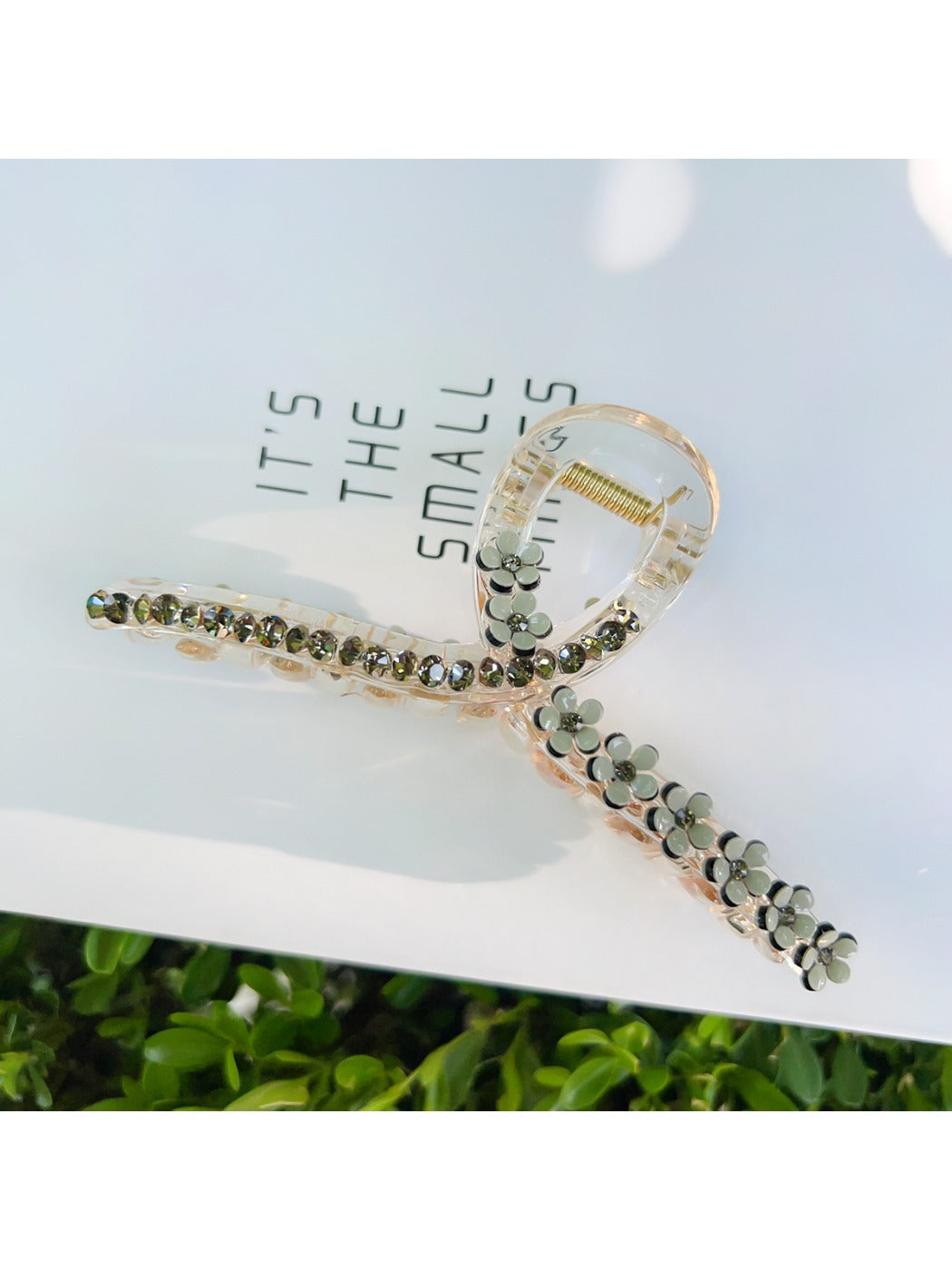 Beau elegant floral cross hair claw clip next to matching floral accessories
