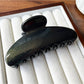 Beau hair clip placed on wooden surface with soft shadows