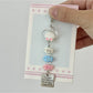 Pastel pink fish-shaped keychain held in hand showing size and texture