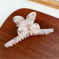 Beau hair claw clip resting on wooden surface with soft lighting