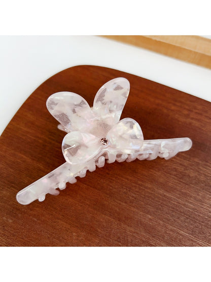 Beau hair claw clip resting on wooden surface with soft lighting