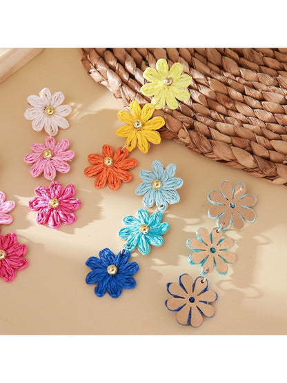 Pair of vibrant flower shaped drop earrings displayed on a white background